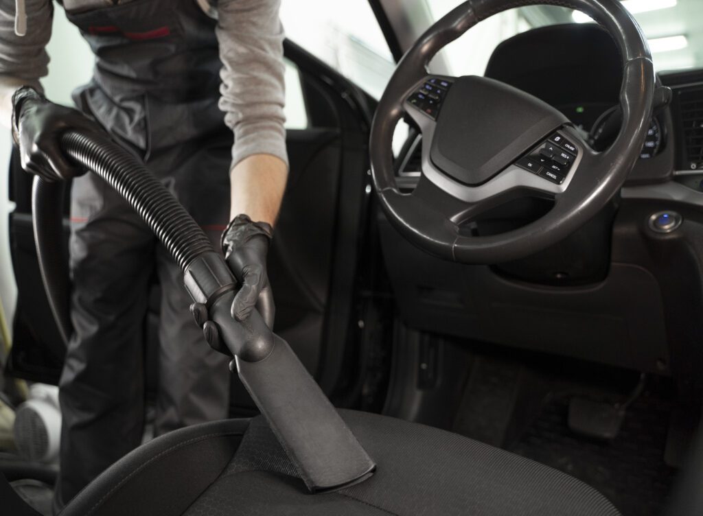 Vacuuming interior of car. Detailing inside of vehicle.